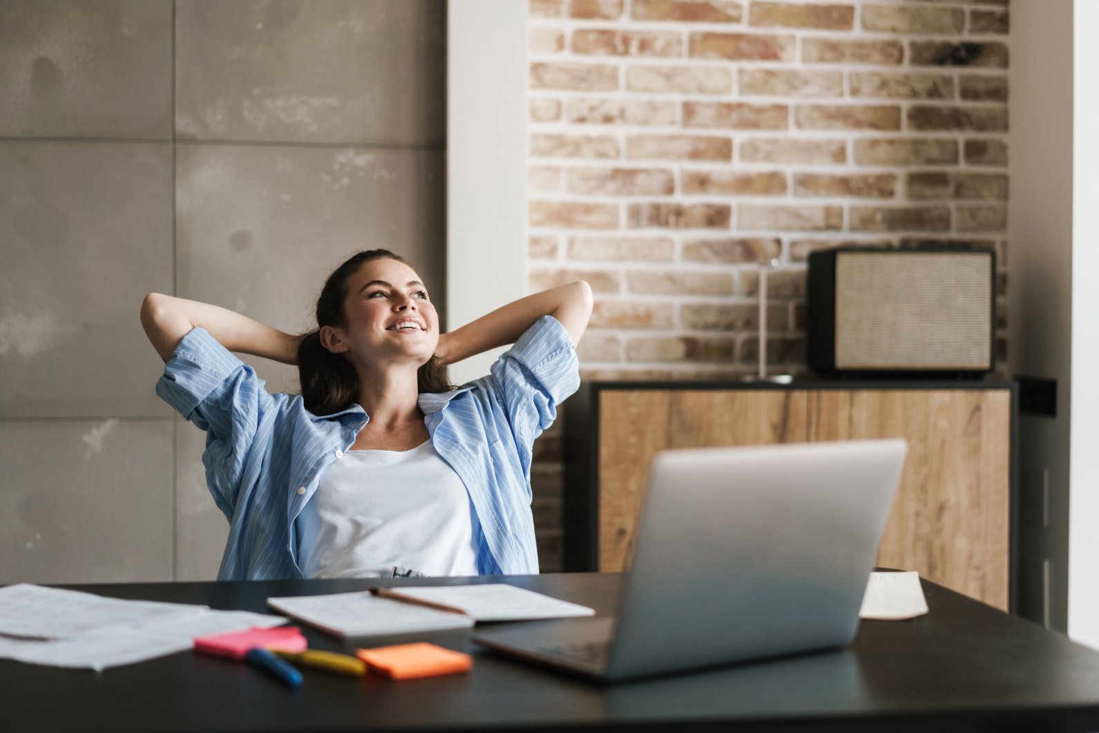 Happy Girl Indoors at Home Relaxing near Laptop Computer